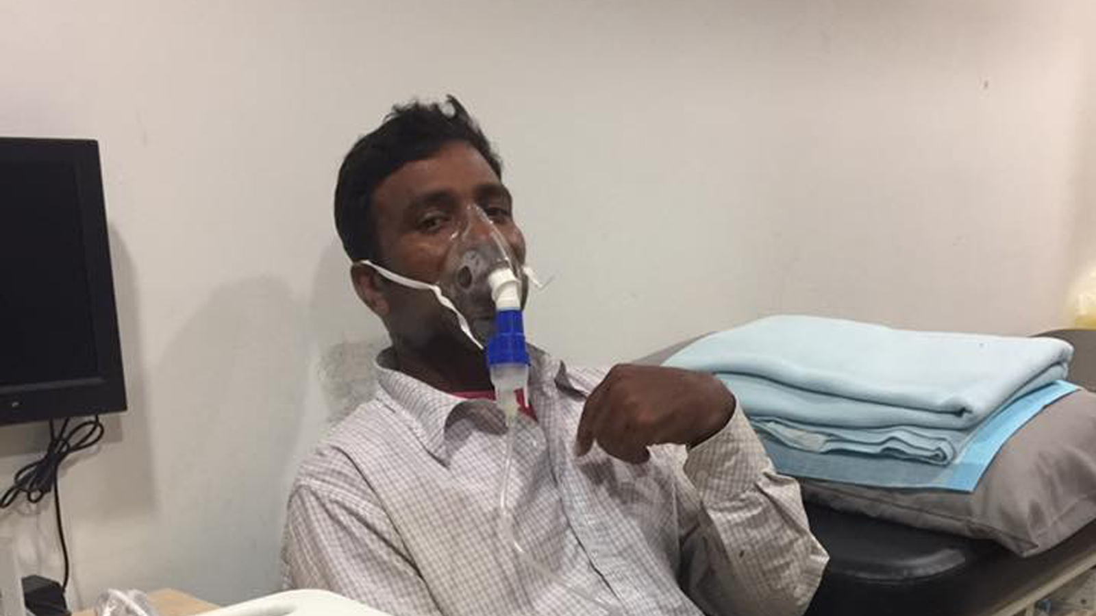 Clinic staff and patient help migrant worker who suffered an asthma attack