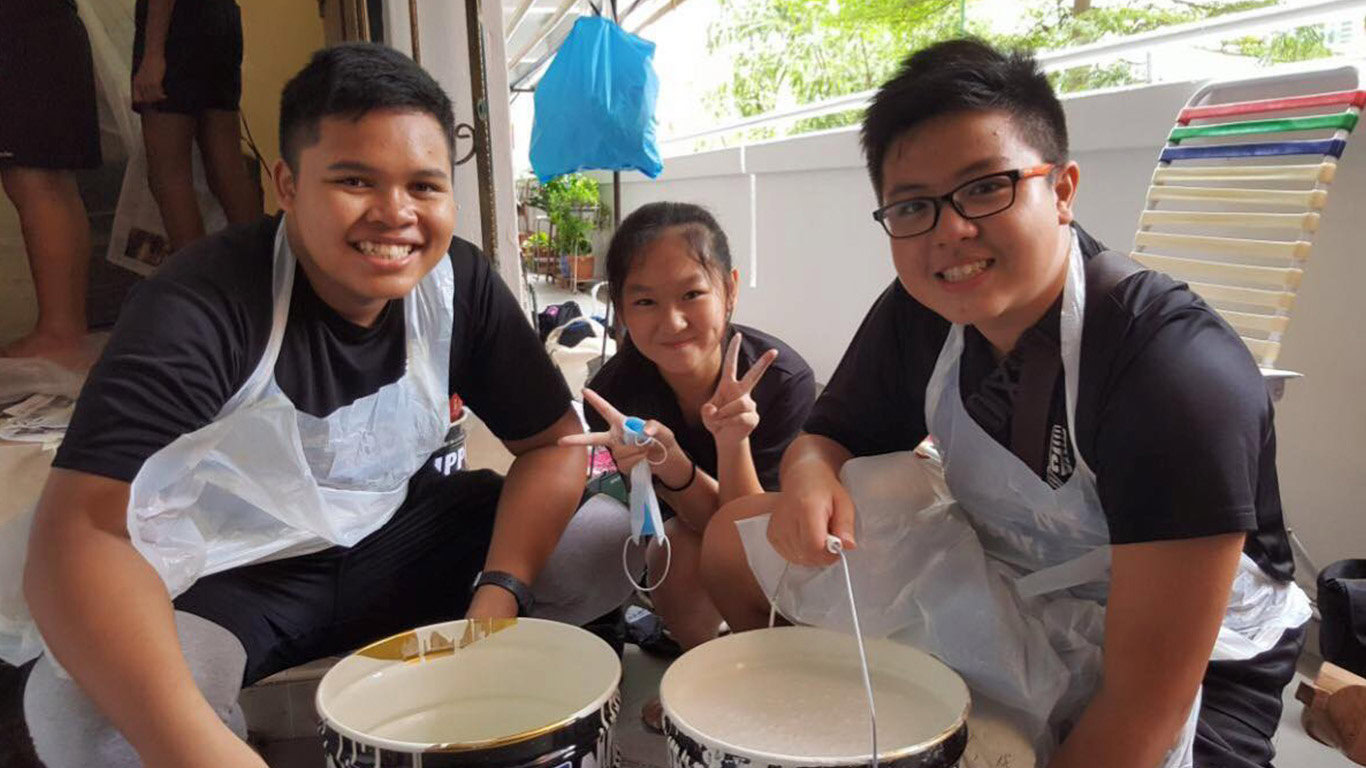 Student volunteers from Singapore's Clementi Town Secondary School posing wih paint buckets