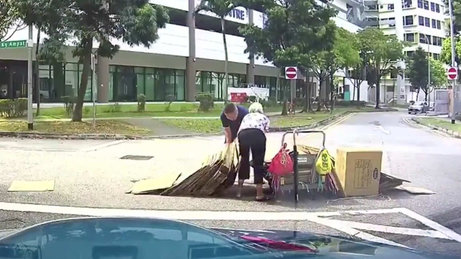 He stops in the middle of the road to help a cardboard auntie in distress