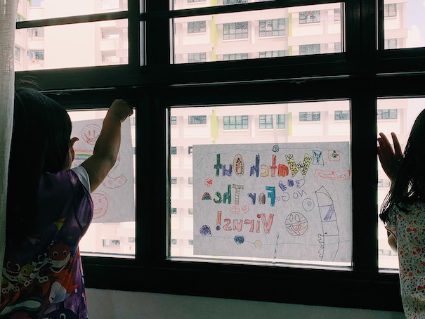 Children putting up their words of encouragement on the window