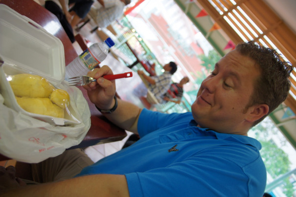 Foreigner trying durian in Singapore