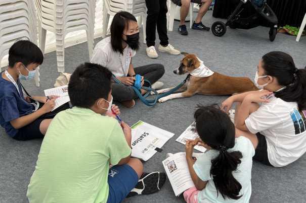 Ru Ting and Mika with a group of children at a Doggie Detectives programme.