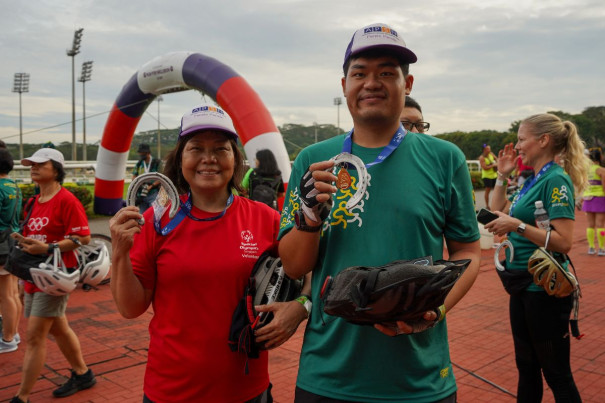 Lucy and Ek Jin with their medals after completing their 20-kilometer cycling event.