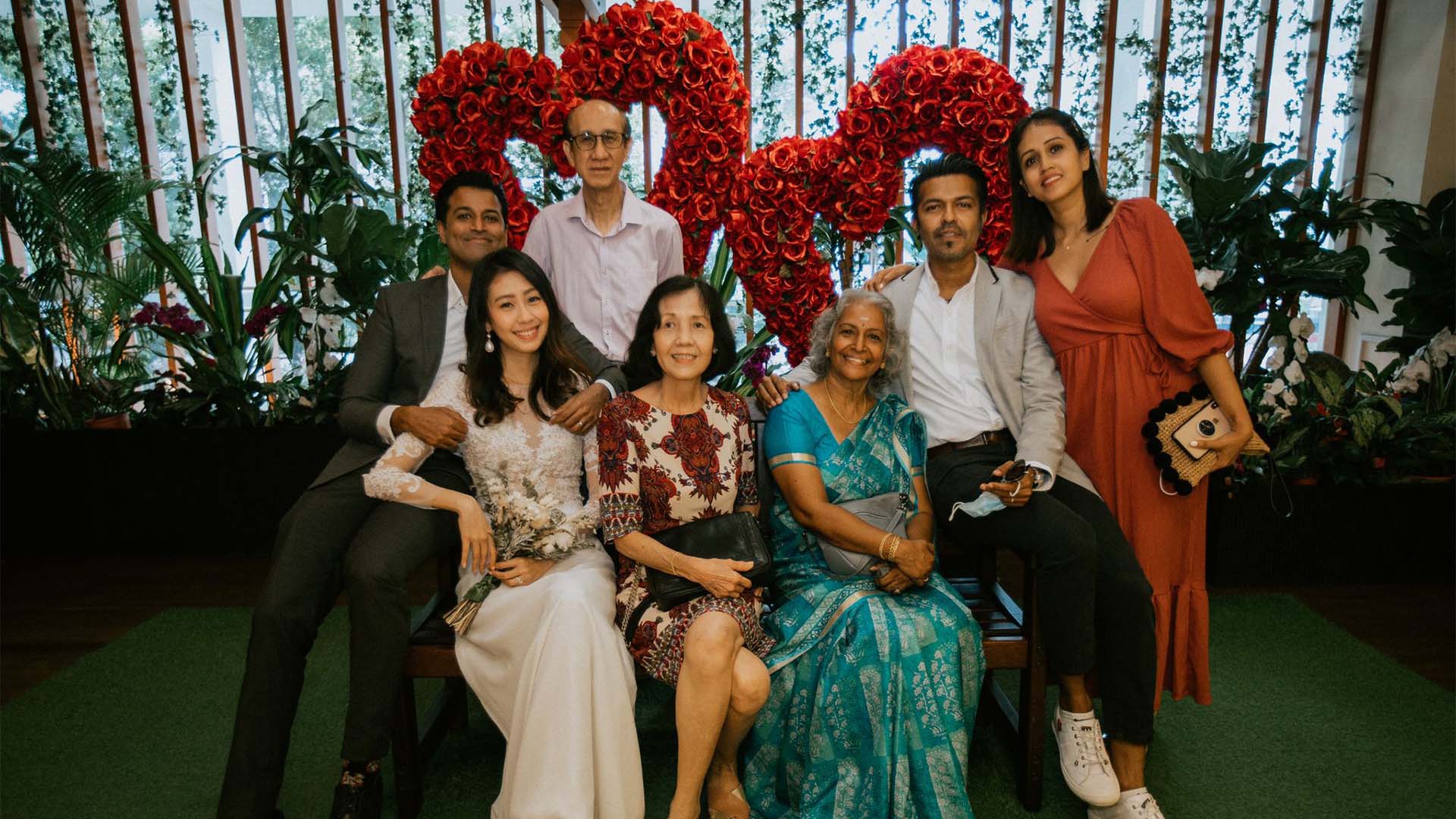 Celebration of diversity and kindness at The Pride event by Singapore Kindness Movement, featuring a diverse group of people smiling and showing unity with a heart-shaped floral backdrop.