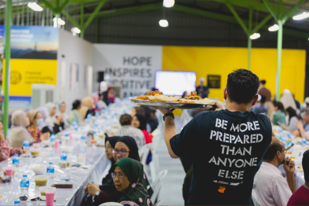 A volunteer serving biryani to beneficiaries during a ramadan iftar event