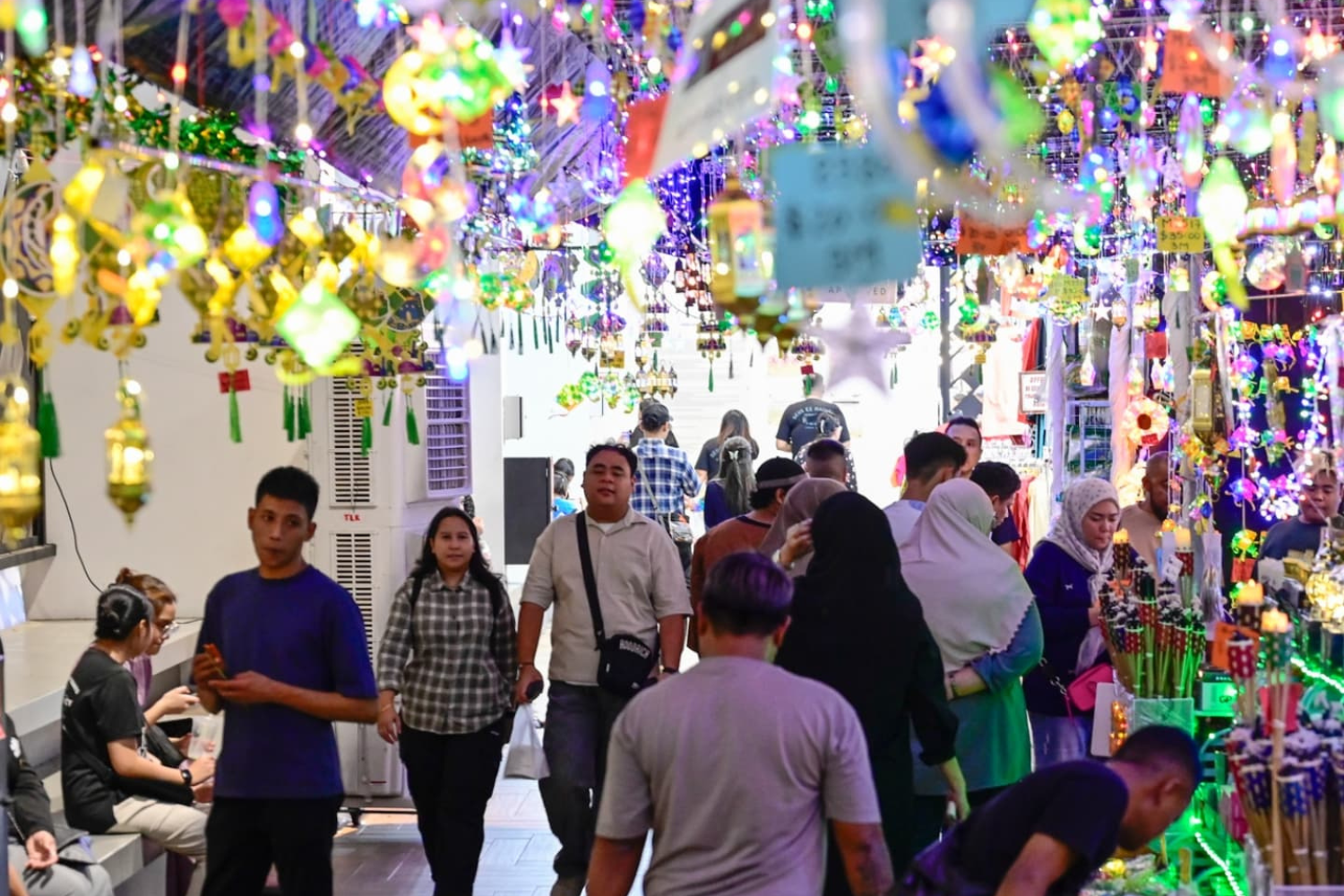 Colorful lanterns and hanging decorations at Singapore kindness movement Pride event, lively crowd enjoying cultural festival, illuminated market stall, Singapore Pride celebration.